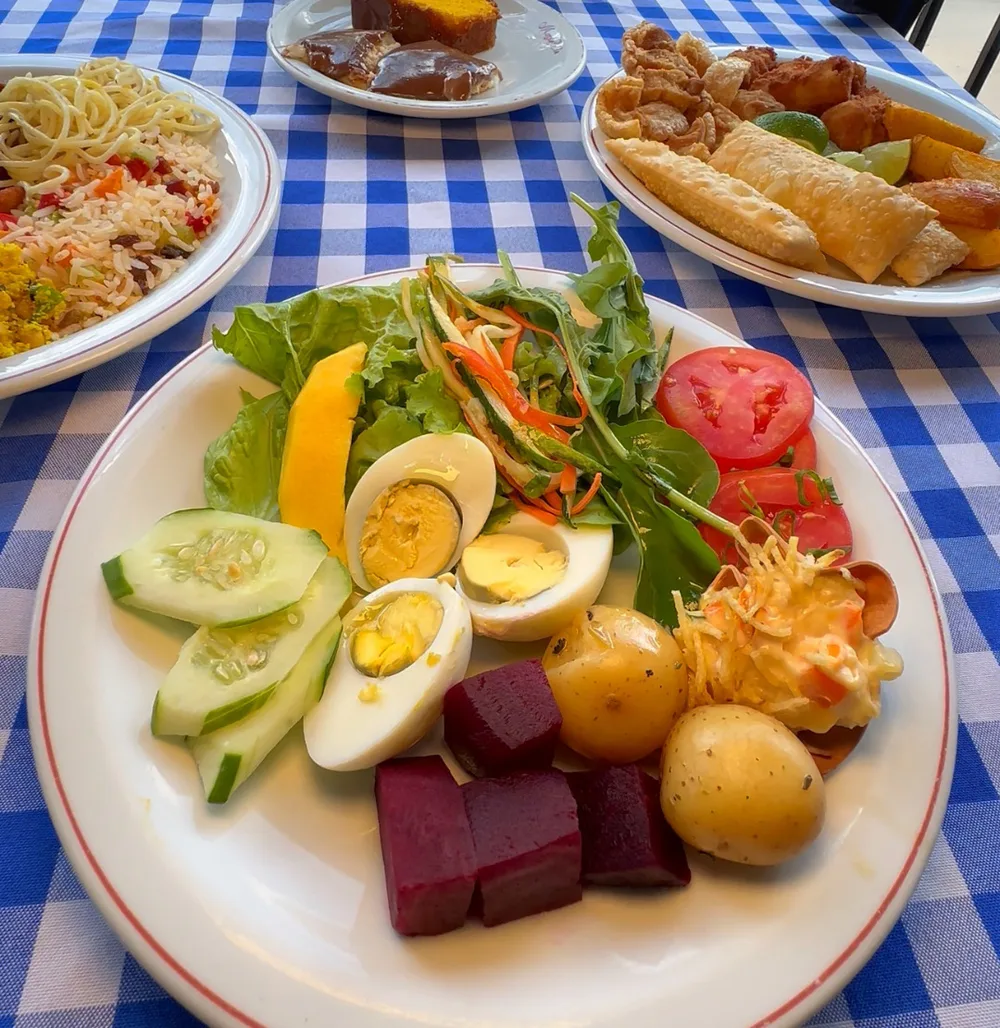 Prato montado no buffet, com saladas e ovos cozidos